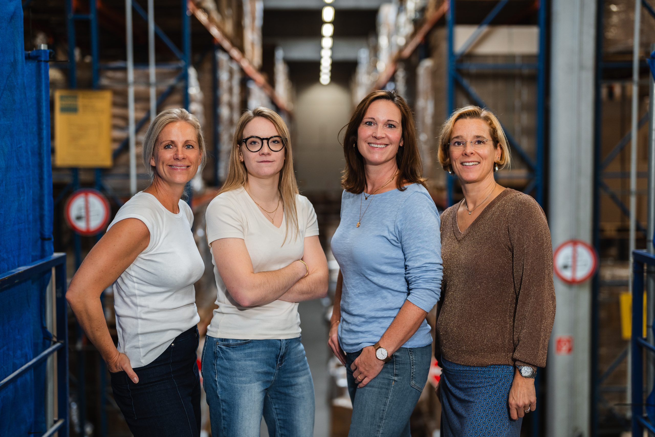 Das UPLOAD-Team zwischen Hochregalen in einer Logistikhalle